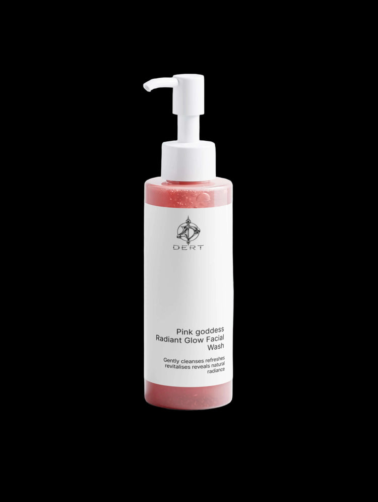 A bottle of Anneux Radiant Glow Facial Wash with a white pump dispenser and a white label, containing a pinkish-red cleanser, set against a clean white background.