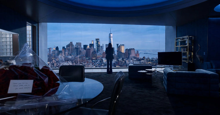 A lone silhouette before a wall of glass, a city skyline at blue hour beyond